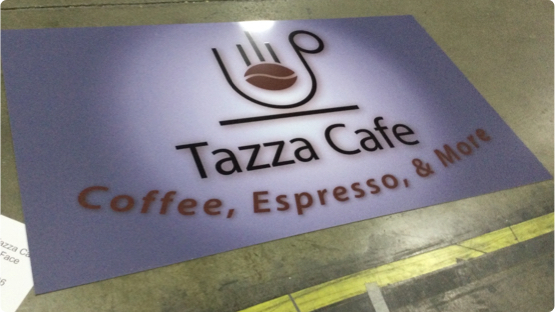 Tazza Café Logo printed on paper sign laying on factory floor