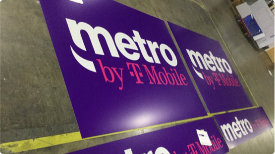 Metro by Tmobile Logo printed on paper sign laying on factory floor