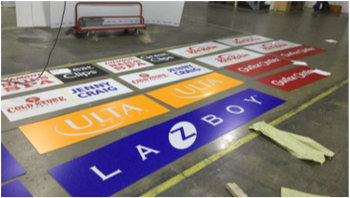 Various company logos printed on paper laying across factory floor